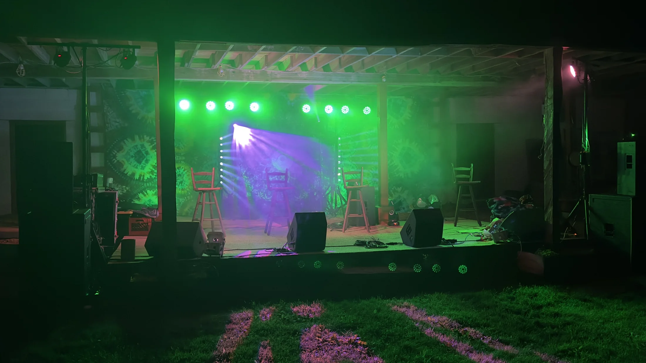 Outdoor stage illuminated with green and violet lighting